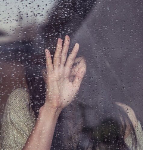 A woman crying by the glass window.